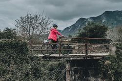 Female riding bicycle on bridge