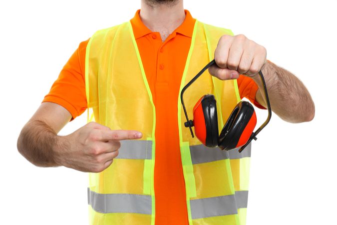 Young man civil engineer with ear protectors isolated on light background