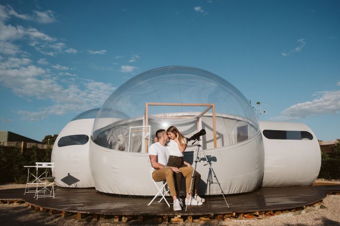 Young couple using astronomical telescope