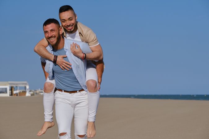 Happy gay couple playing piggyback