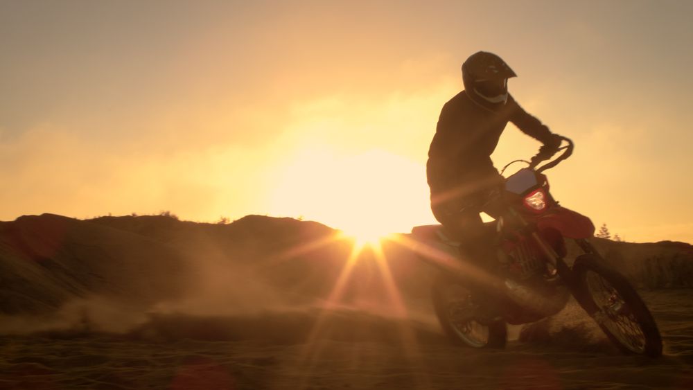Professional Motocross Motorcycle Rider Drives on the Off-Road Sand Terrain.