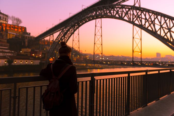 Woman looking at river and city in evening