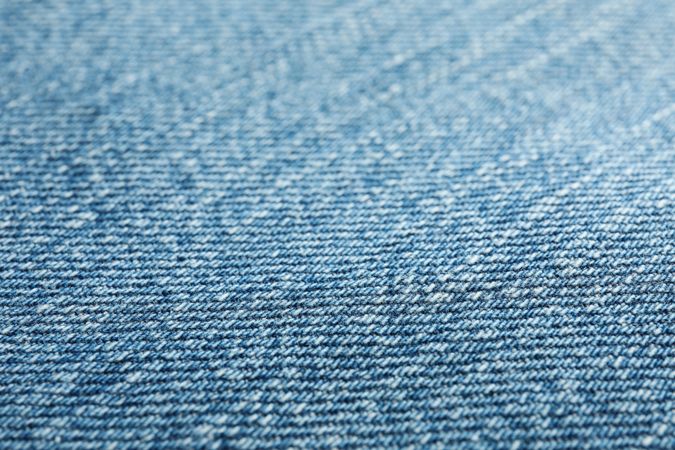 Texture of blue jeans as background, space for text