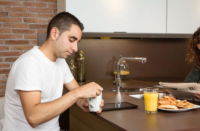 Man with coffee on kitchen island