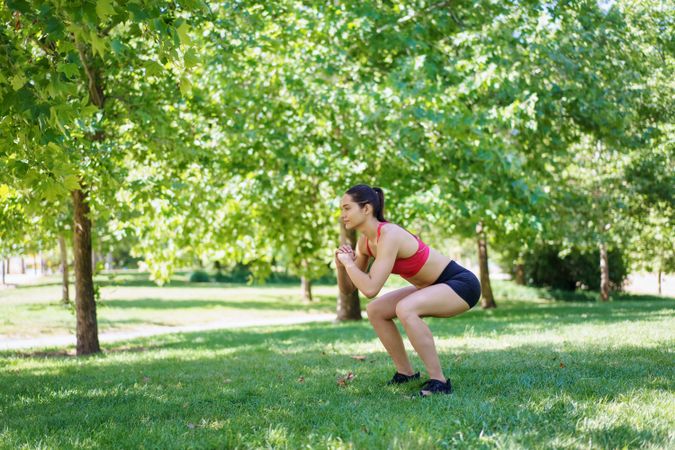 Woman squatting in park