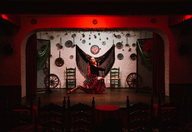 Woman dancer in flamenco costume standing in dance posture