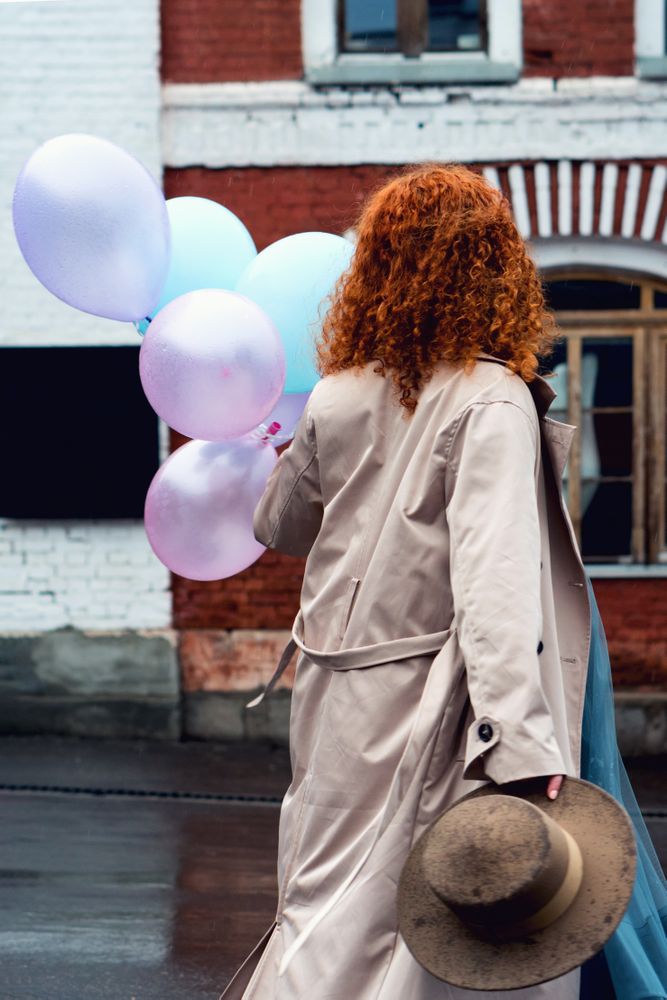 Woman walks streets with bunch balloons
