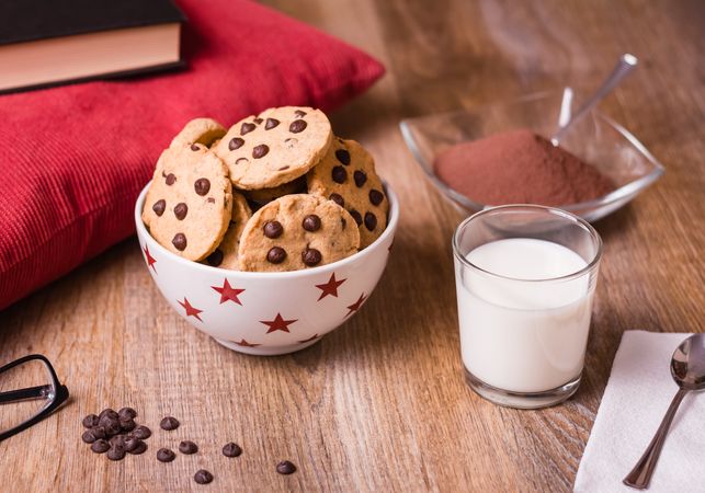 Chocolate chip cookies and milk on wood background