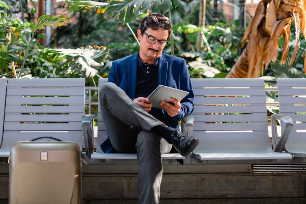 Older handsome man using digital tablet outdoors