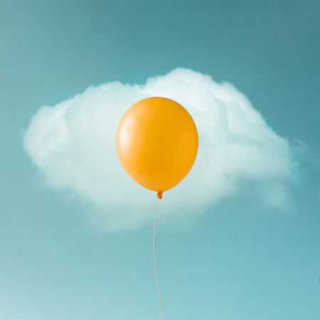Yellow balloon with  cloud on blue sky in shape of an egg