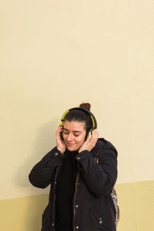 Satisfied woman smiling while listening to music in earphones