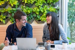 Happy man and woman talking while having a business meeting in cafe