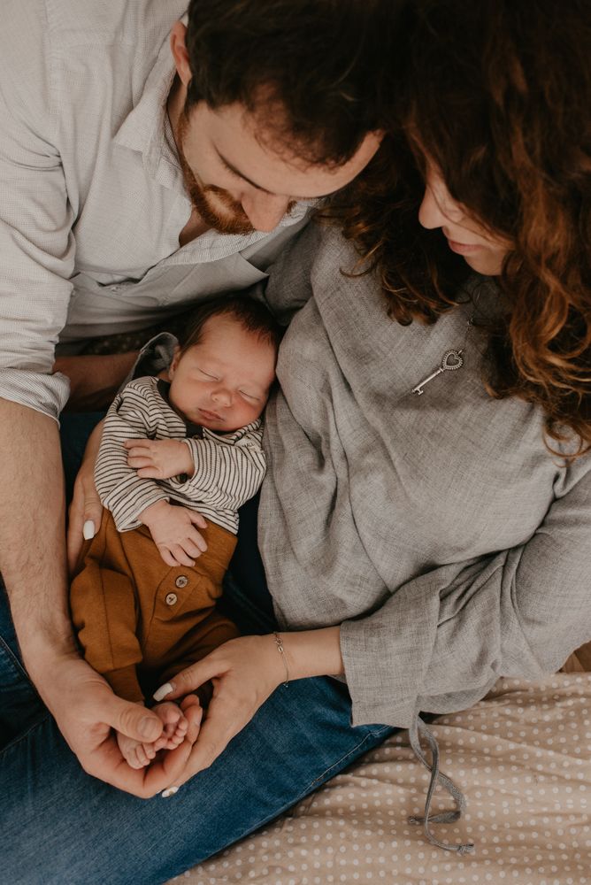 Top view of mother and father watching their baby sleeping