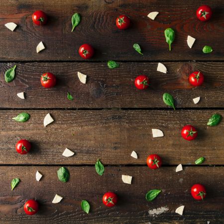 Basil, tomatoes, and cheese on wooden background