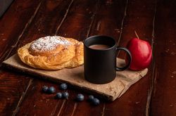 Fresh fruits near bun and hot drink