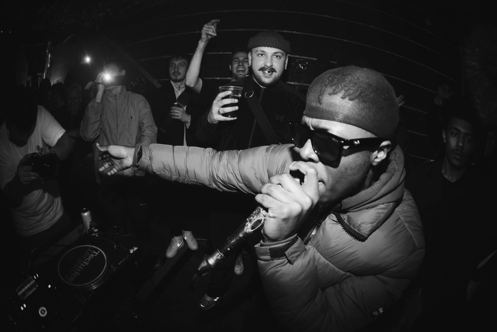 Close-up shot of young performer rapping on microphone at show