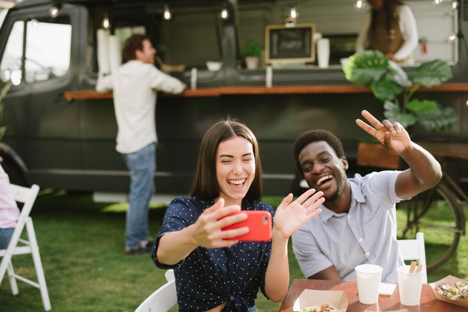 Diverse friends talking selfie near food truck