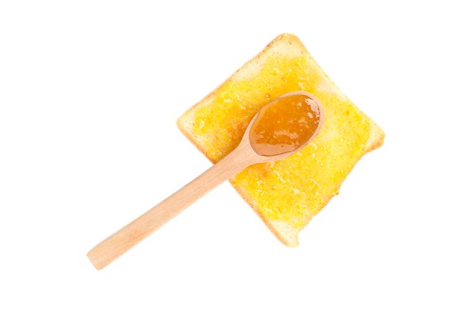 Spoon and toast with orange jam isolated on plain background