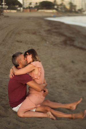 Delighted couple sitting on beach