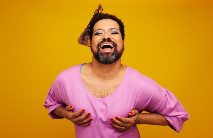 Gender fluid person posing on yellow background