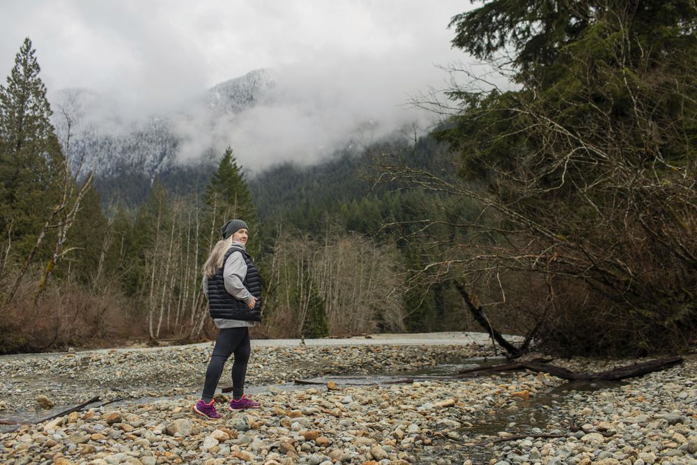 Woman in the mountains walking near a stream