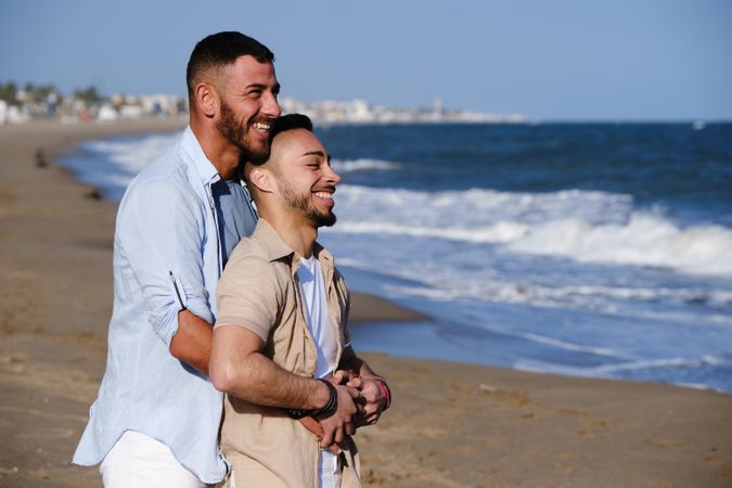 Male couple hugging on seaside