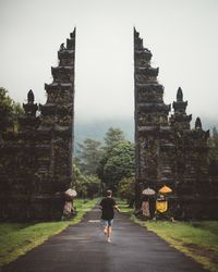 Man running into gates of ancient temple