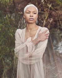 Contemplative woman in mesh dress outside