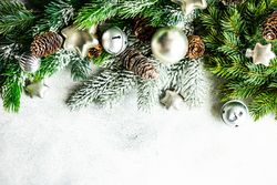 Christmas frame concept with pine branch and golden baubles