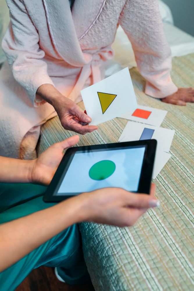 Female doctor showing geometric shapes to older patient