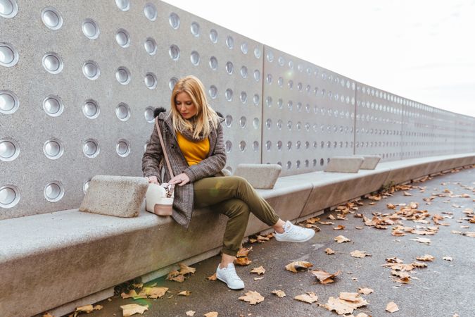 Portrait of blond woman looking in her bag