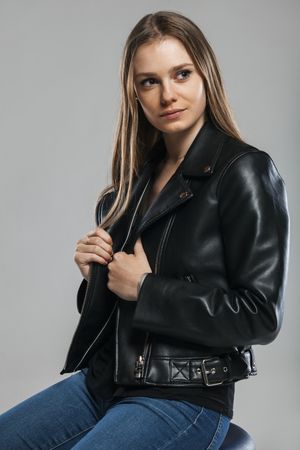 Blonde female with leather jacket posing in studio