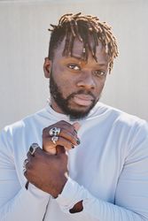 Serious stylish Black man touching wrist