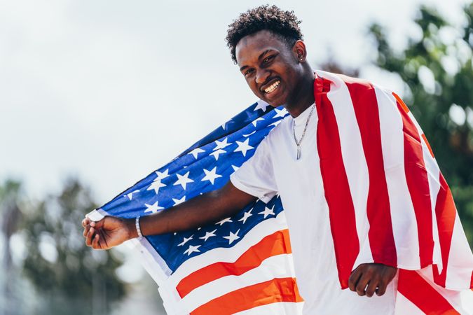 Black man in American Flag outside