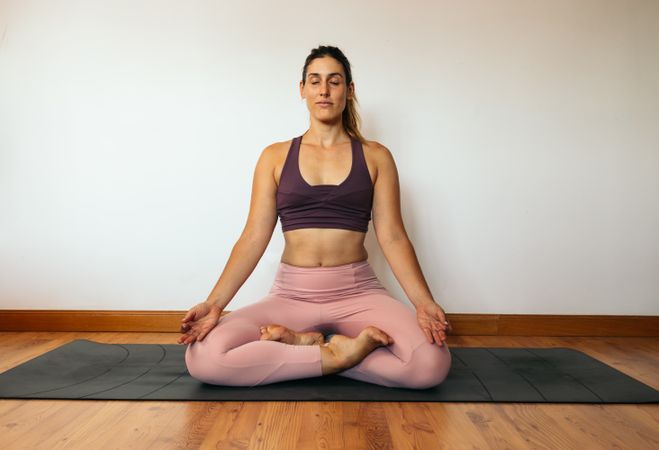 Woman in sportswear doing yoga at home