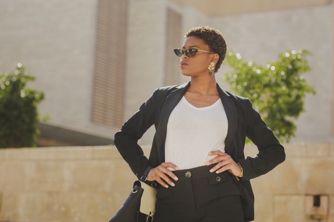 Stylish Black woman with handbag and sunglasses on street