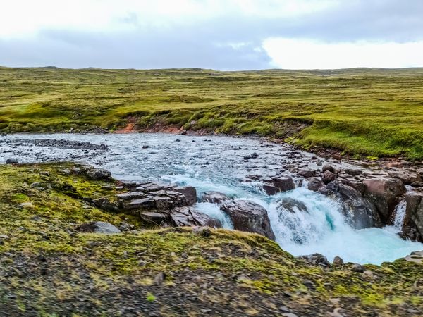 Majestic icelandic waterfall cascading through green landscape