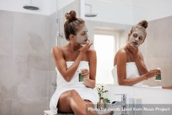 Young woman sitting in bathroom and applying facepack 5n6225
