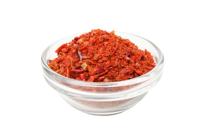 Bowl with pepper powder spice isolated on blank background