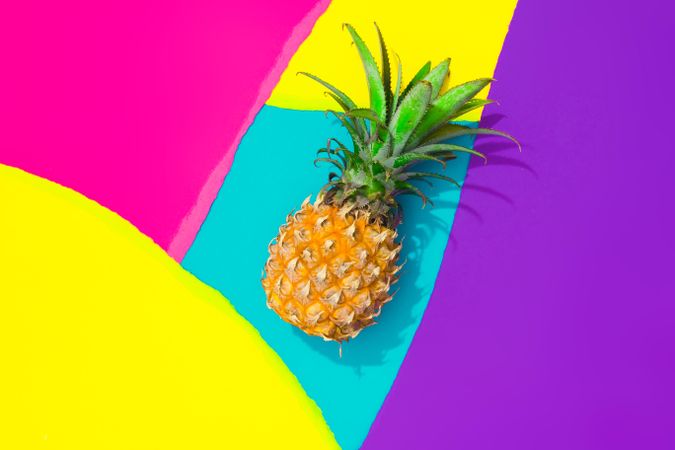 Pineapple on pattern of ripped paper in vivid colors