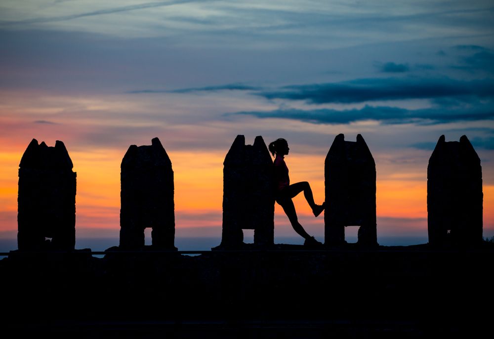 Silhouette of person between stone sculptures in sunset