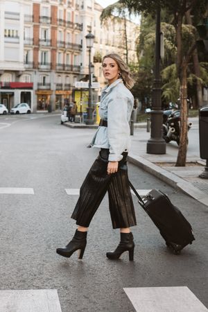 Cheerful female tourist crossing street