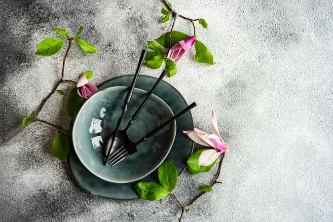 Top view of bowl & plate with magnolia flowers on grey counter