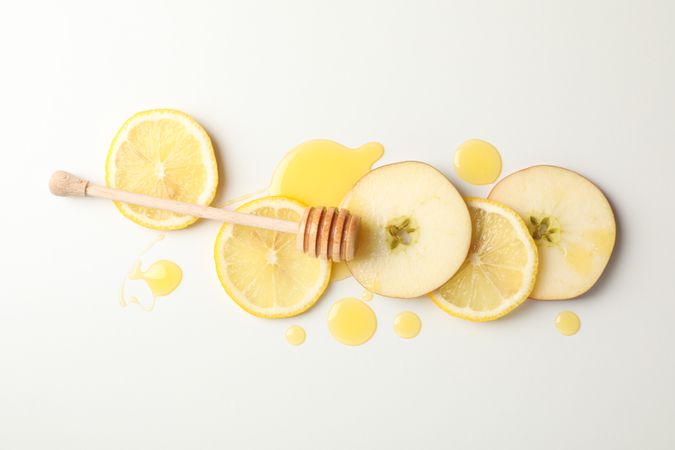 Dipper, honey, apple and lemon slices on blank background, top view