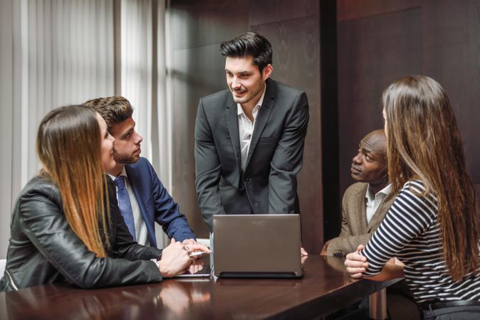 White male giving a talk to his colleagues in a meeting at work