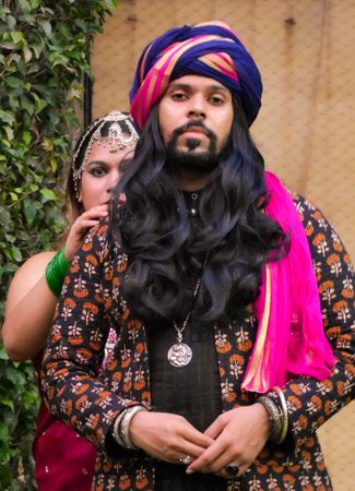 Indian man wearing a turban and woman standing right behind him