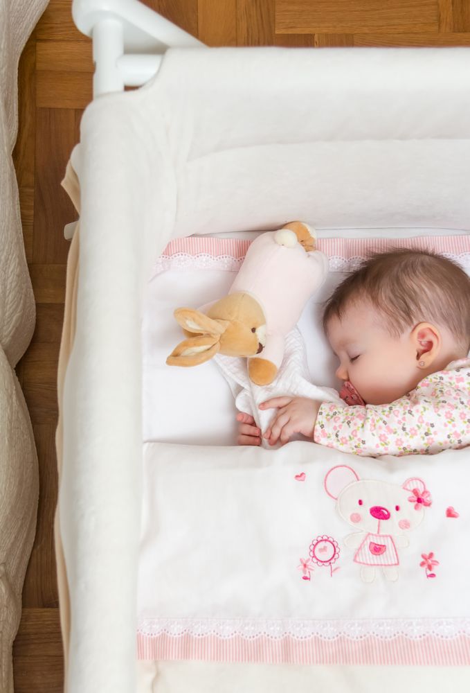 Baby girl sleeping with pacifier and toy