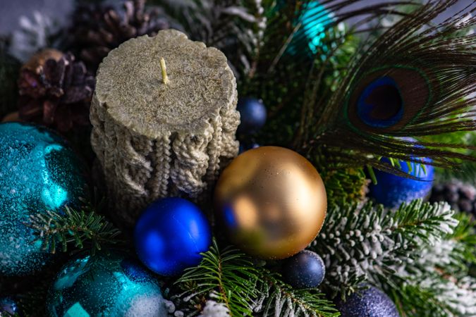 Blue and gold Christmas decorations in pine centerpiece with peacock feathers