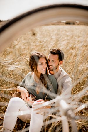 Loving couple resting on rye field