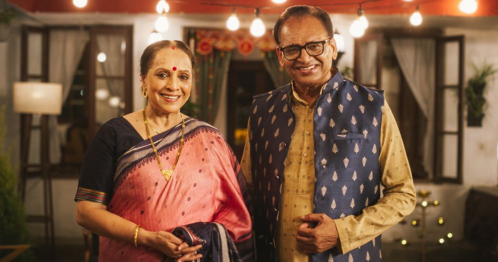 Portrait of Happy Indian Older Couple in Traditional Clothes Posing Together at Their Authentic Mumbai Home.